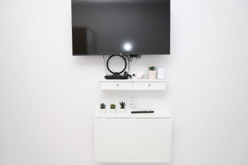 a flat screen tv on top of a white wall at Saska Kępa Luxe Apartment in Warsaw