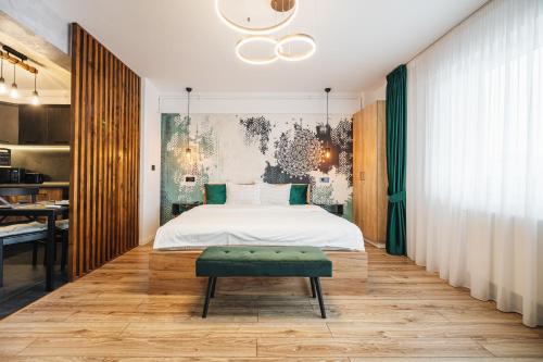a bedroom with a white bed and a green bench at A Guesthouse Sibiu in Sibiu