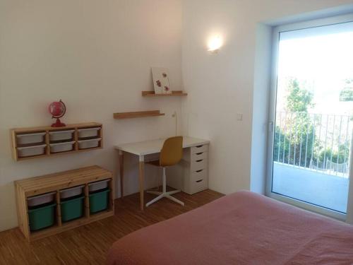 Schlafzimmer mit einem Schreibtisch, einem Bett und einem Fenster in der Unterkunft Casa moderna julio y agosto in Ferrol
