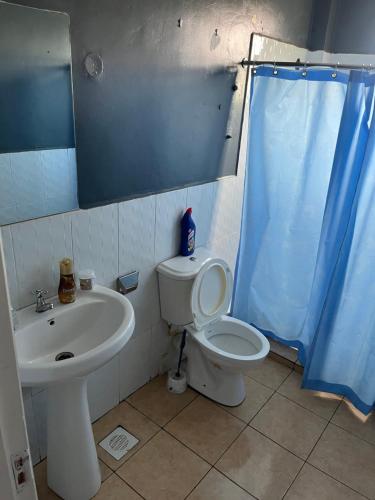 a bathroom with a toilet and a sink at Family-Friendly Home in Nairobi