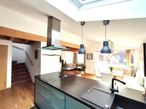 a kitchen with a counter top and a living room at Apartment Baumblick mit Whirlpool in Medraz