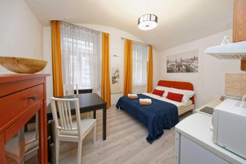 プラハにあるRiverside Apartmentのベッド1台、デスクが備わる小さな客室です。