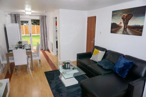 een woonkamer met een zwarte bank en een tafel bij The Oasis in Wigan