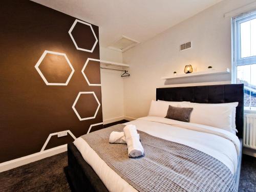 a bedroom with a large bed and a wall with hexagons at Cosy modern 1 Bedroom apartment! in Liverpool