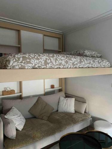 - une chambre avec 2 lits superposés et un canapé dans l'établissement Joli studio paris 17, à Paris