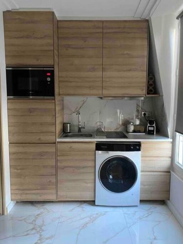 une cuisine avec une machine à laver et un évier dans l'établissement Joli studio paris 17, à Paris