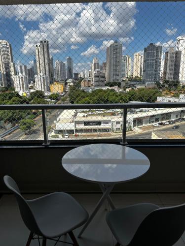 a table and chairs in a room with a view of a city at Apartamento mobiliado a 500m do Goiânia Shopping in Goiânia