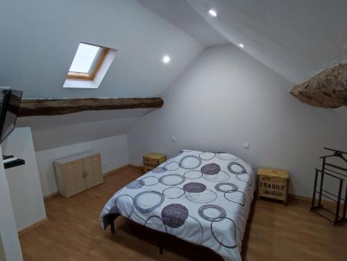 une chambre avec un lit dans un grenier dans l'établissement La maison de vos vacances, à Marmeaux