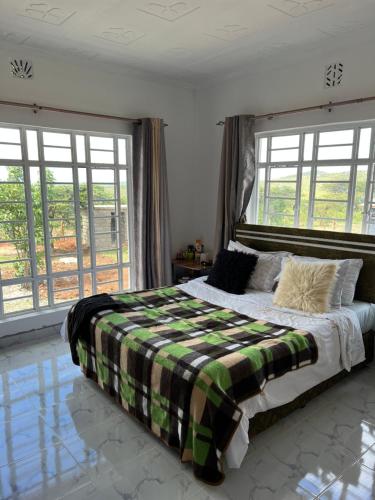 um quarto com uma cama com um cobertor xadrez em Nashipae Cultural Oasis em Ololaimutiek