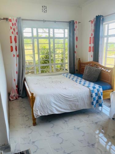 a bedroom with a bed and a large window at Nashipae Cultural Oasis in Ololaimutiek