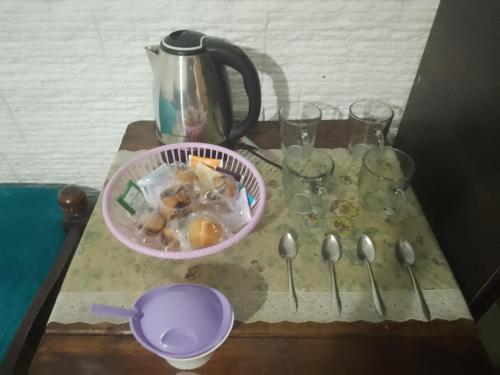 una mesa con tetera, vasos y cucharas en Trinidad Hostal en San Salvador de Jujuy