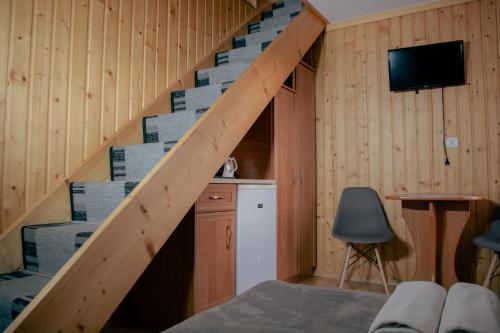 eine Holztreppe in einem Zimmer mit einem Tisch und einem Stuhl in der Unterkunft Pokoje Gościnne Bożena Dunajczan in Brzegi