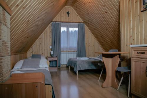 een slaapkamer met 2 bedden en een raam op zolder bij Pokoje Gościnne Bożena Dunajczan in Brzegi