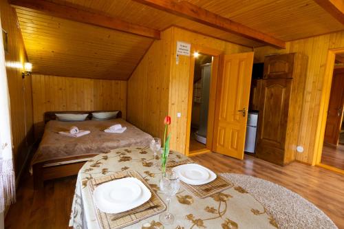 a room with a bed and a table with plates on it at Садиба У Василини та Романа in Bukovel