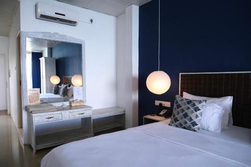um quarto com uma cama e um espelho grande em BeachMirissa Hotel em Mirissa