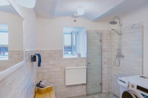 Un baño blanco con ducha y lavabo. en Chalupa Na Rachačkách, en Kamenice nad Lipou