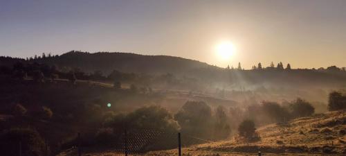 un amanecer nebuloso en una colina con la puesta de sol en Garden Village Retreat, en Bughea de Sus