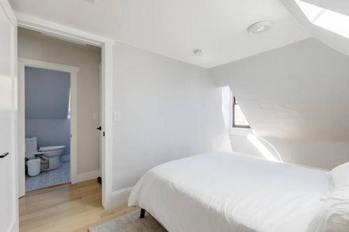 een witte slaapkamer met een bed en een badkamer bij Denver Haven with Rocky Mountain Views in Denver