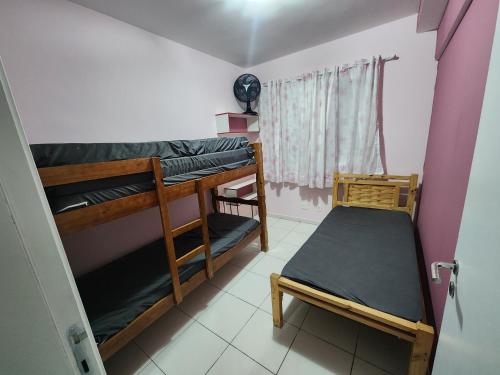 Cette chambre comprend 2 lits superposés et une fenêtre. dans l'établissement Costa do Sol, à Praia Grande