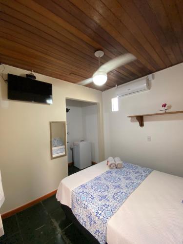 a bedroom with a bed and a flat screen tv at Recanto da Bruna in Abraão