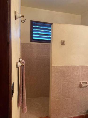 a bathroom with a shower with a window at Casa Mex in Pisté