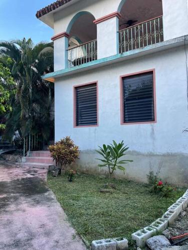 a white house with a balcony on top of it at Casa Mex in Pisté