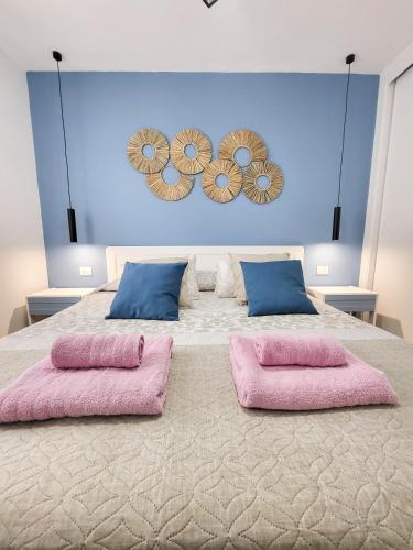 a bedroom with a large bed with pink pillows at Optimist las americas in Playa de las Americas