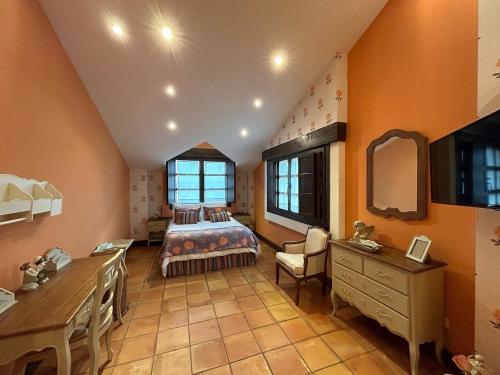 a bedroom with a bed and a desk and a mirror at La Flor del Granado in Torrijos