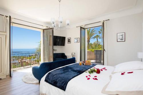 a bedroom with a bed with a view of the ocean at LE CASTEL ROSE Super Cannes, face aux Îles de Lérins in Vallauris