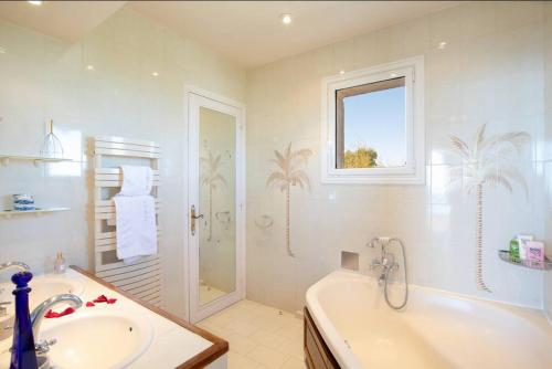 uma casa de banho com uma banheira, um lavatório e um chuveiro em LE CASTEL ROSE Super Cannes, face aux Îles de Lérins em Vallauris