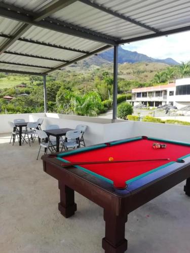 a pool table in a patio with tables and chairs at Hosteria Cefcaloma in Santa Isabel