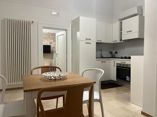 - une cuisine et une salle à manger avec une table et des chaises dans l'établissement Antiche Mura Apartments"Bianco di Puglia" cucina 1 camera da letto più divano letto, à Turi