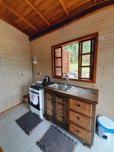 una cucina con lavandino e piano cottura di Casa da Cachoeira Siriú-SC a Garopaba