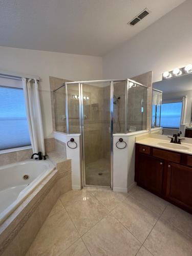 a bathroom with a shower and a tub and a sink at Susan’s Place in Deltona