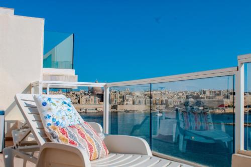 a balcony with a chair and a view of the city at Exceptional Tigne Seafront Apartments by Shortletsmalta in Sliema