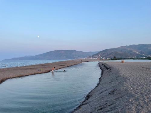 a person standing in the water on a beach at Azur by Azur spacieux, emplacement idéal et proche de la plage in Oued Laou