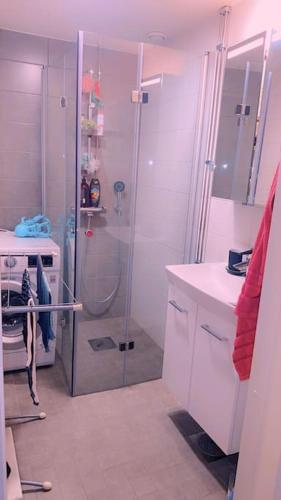 uma casa de banho branca com um chuveiro e um lavatório. em Room in Helsinki area em Helsinque