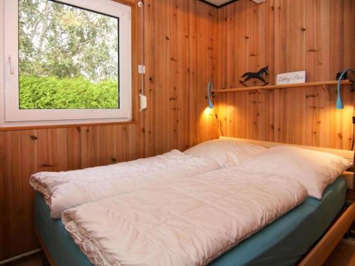 a large bed in a room with a window at Attractive bungalow at the North Sea in Warwerort in Warwerort
