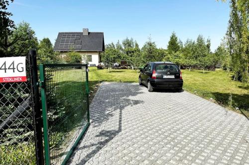 a car parked in a driveway next to a fence at Uroczy duży dom nad jeziorem z prywatną przystanią in Steklinek