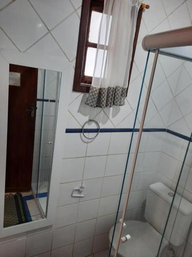 a bathroom with a shower and a toilet at Pousada Icthus in Cabo Frio