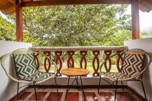 two chairs and a table on a balcony at Portales del Tayrona Garden Hotel in Calabazo
