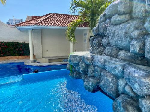 a swimming pool with a rock wall next to a house at Hotel Playa de Oro - Enfrente de WTC y Plazas Comerciales in Veracruz
