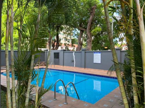 een zwembad met palmbomen eromheen bij Discover Accra's Hidden Gem in Accra
