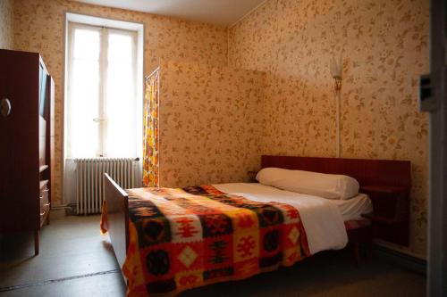 een kleine slaapkamer met een bed en een raam bij La Villa Bouloc, gite pour la famille in Salles-Curan