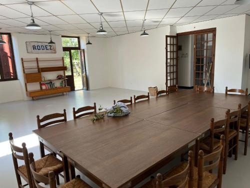 een grote kamer met een grote houten tafel en stoelen bij La Villa Bouloc, gite pour la famille in Salles-Curan