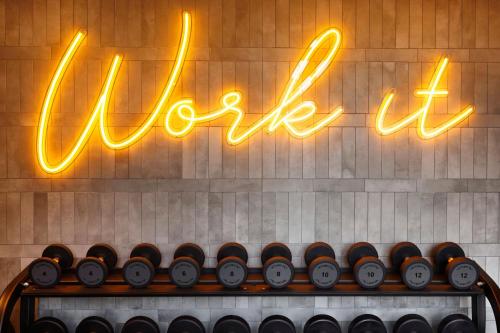 a row of wine bottles on a shelf in front of a sign at Le Meridien Melbourne in Melbourne