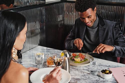 a man sitting at a table eating a plate of food at Le Meridien Melbourne in Melbourne