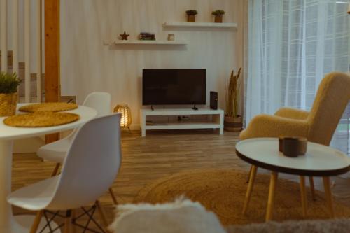 a living room with white chairs and a flat screen tv at Domek na szlaku in Szklarska Poręba