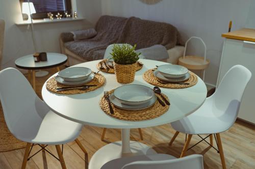 - une table et des chaises blanches dans le salon dans l'établissement Domek na szlaku, à Szklarska Poręba