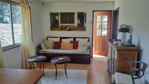 a living room with a couch and two stools at Casa Algarrobo in Algarrobo